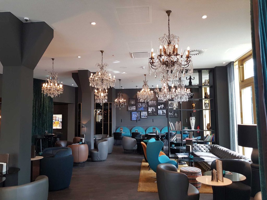 Lounge des Motel One Berlin-Ku’Damm mit mehreren Kristall Kronleuchtern von Light Delux